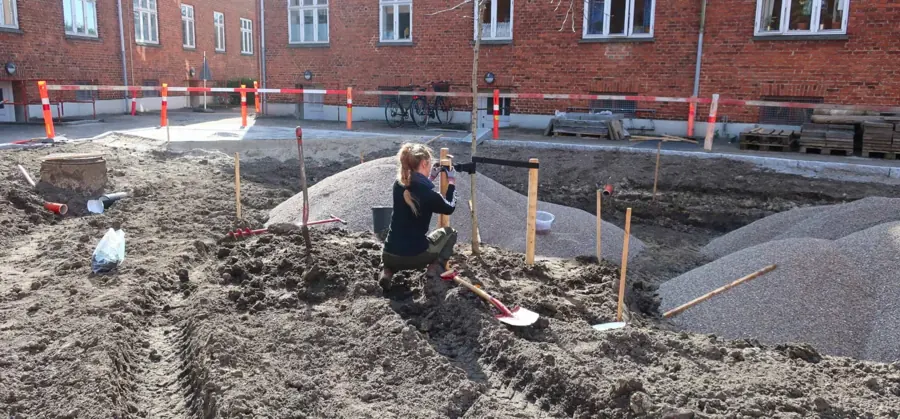 En gartner fra Kasvu Haver etablerer beplantning i et gårdanlæg